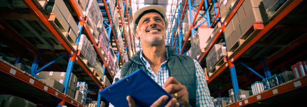 older man working in a warehouse using a WMS